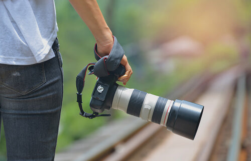 Professional Photographer with Camera on the Rail Road